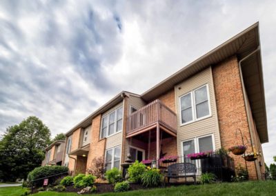 Exterior of Brookfield apartments for rent in Macungie, PA with beautiful front lawn and private balconies on sunny day